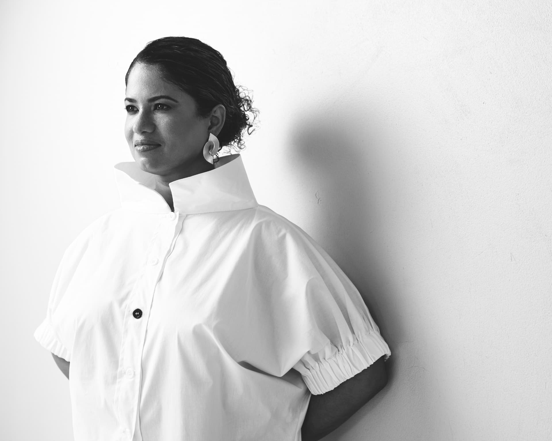 Black-and-white portrait of M. Analise Kandasammy in a white high-collared shirt, looking off-camera